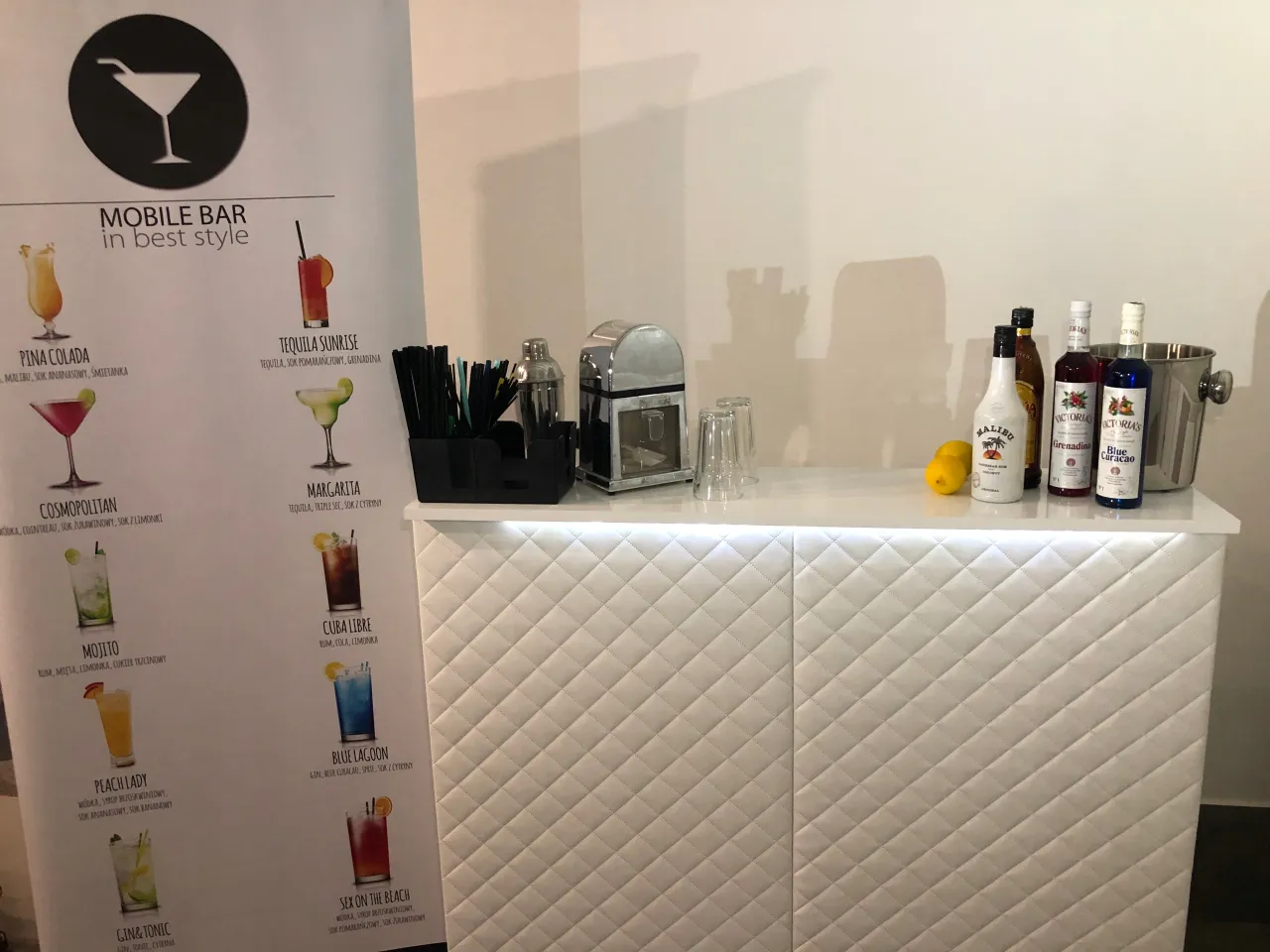 Mobilny bar oferuje drinki, co zamiast drink baru? Na blacie stoją butelki z alkoholami, shaker i szklanki.