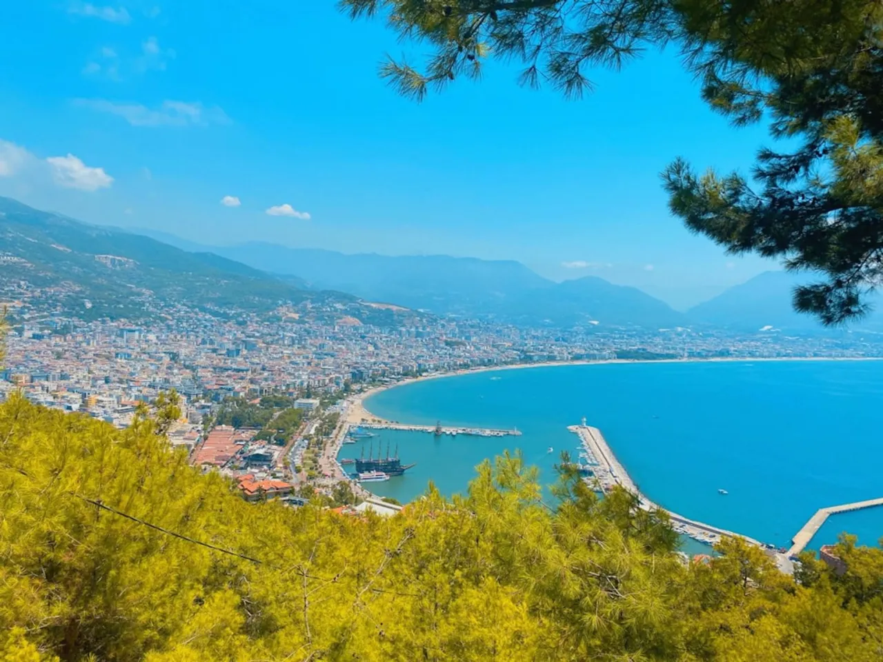 Widok na Alanyę w Turcji. Miasto rozciąga się wzdłuż wybrzeża Morza Śr&oacute;dziemnego, otoczone g&oacute;rami. Czy jest bezpiecznie? Tak, to popularny i bezpieczny kurort.