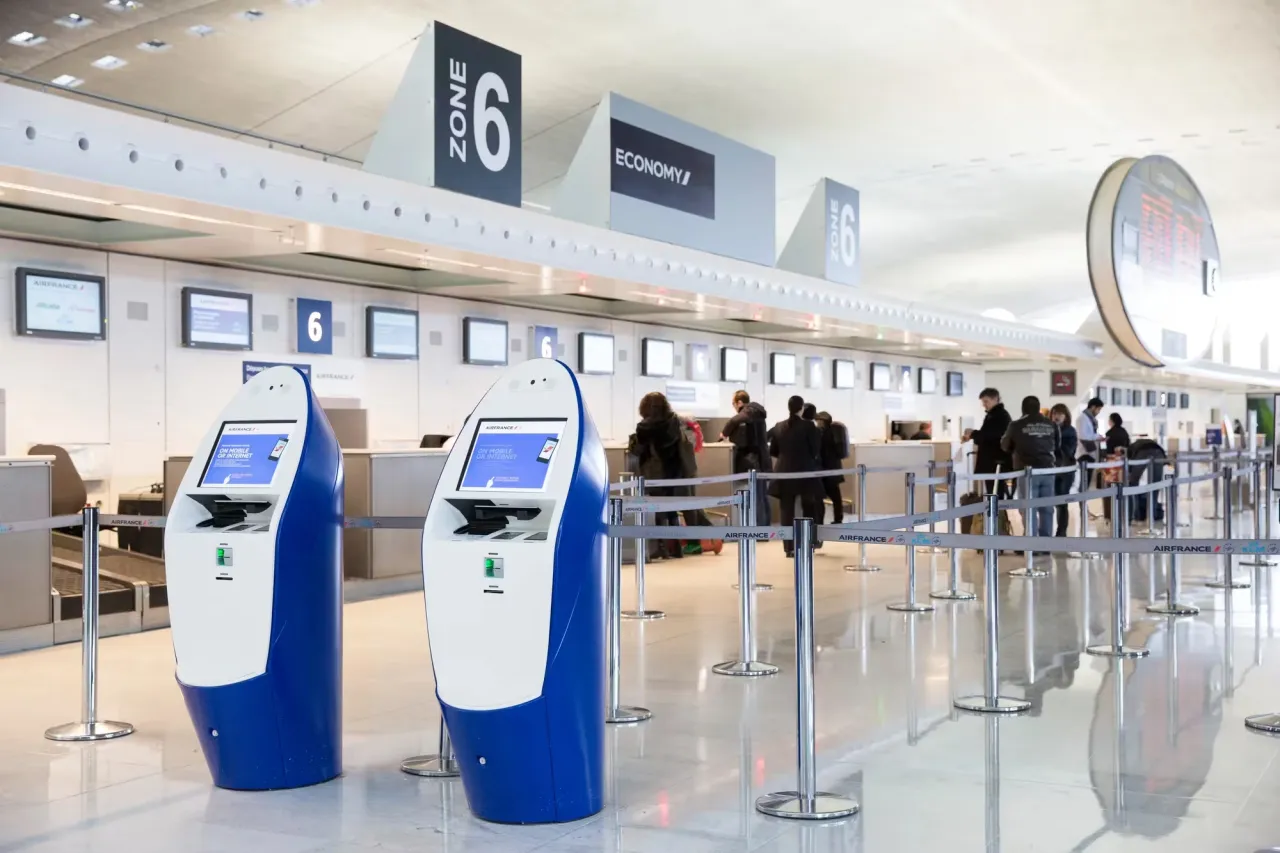 Voyageur enregistrant une valise au comptoir Air France dans un a&eacute;roport