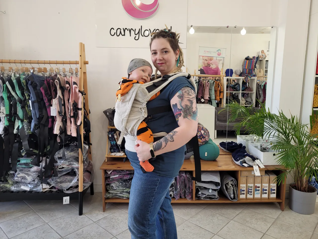 Dziecko w nosidle przodem z nienaturalnie wyprostowanym kręgosłupem