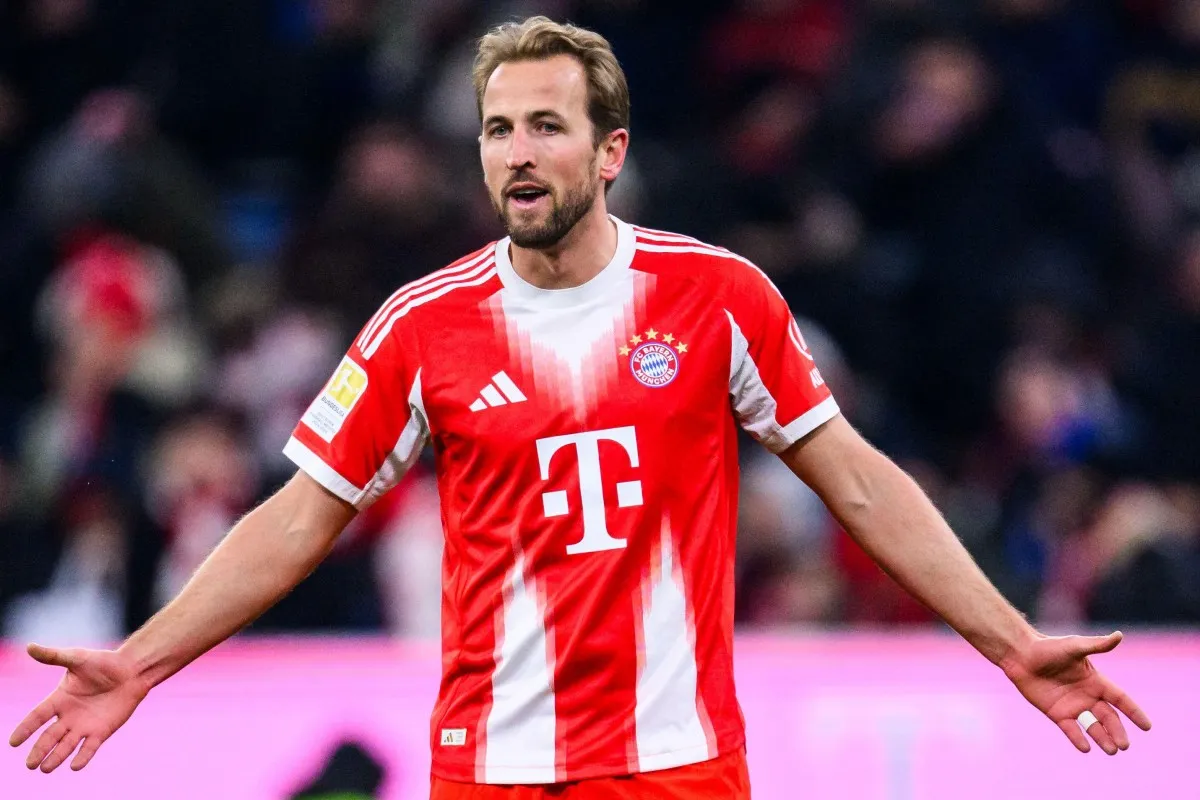 Piłkarz Harry Kane w czerwonej koszulce Bayernu Monachium, zastanawia się ile zarabia.