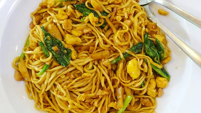 Gebratene Nudeln mit Ei in einer gusseisernen Pfanne