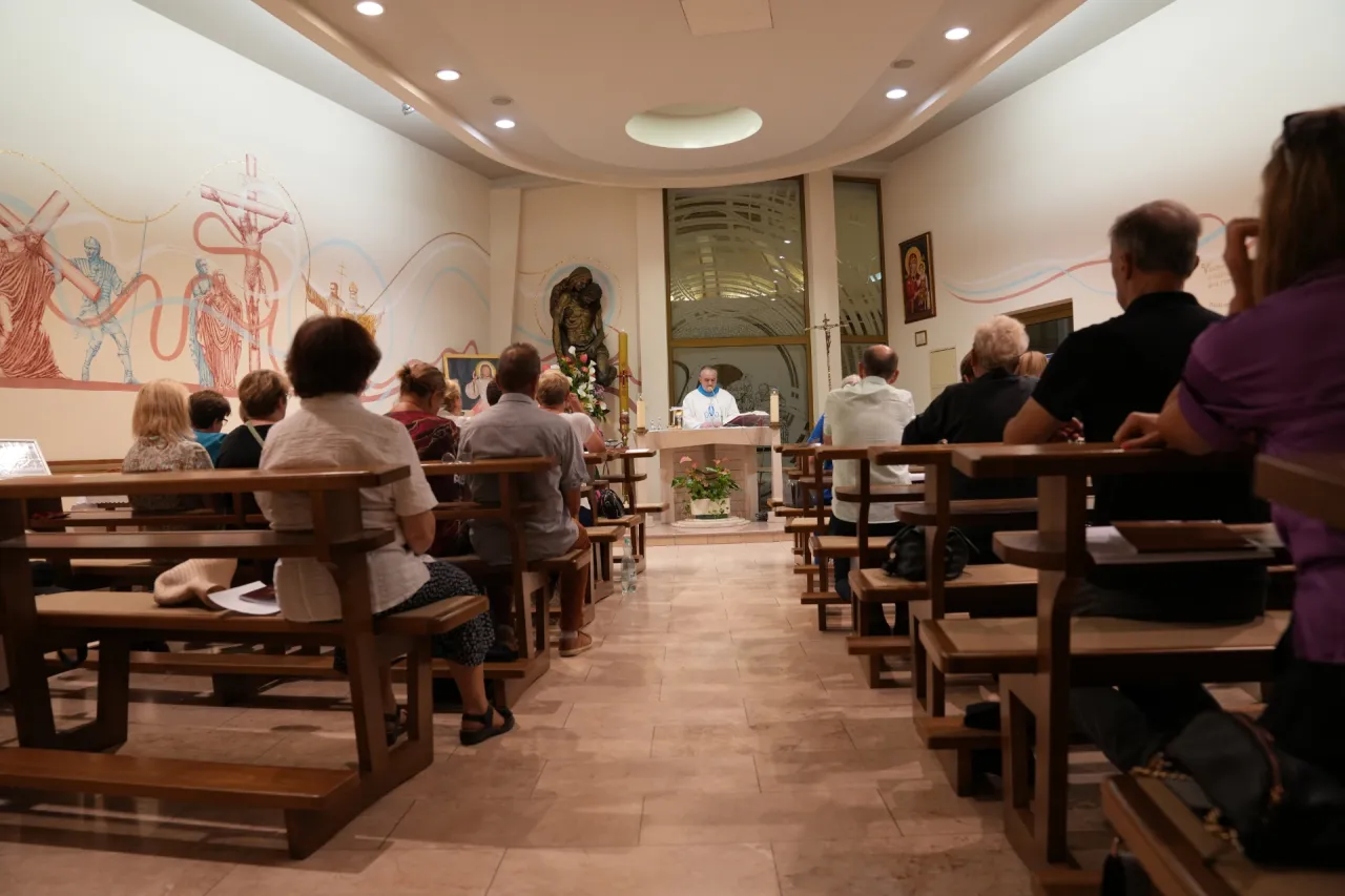 Rodzic z dzieckiem siedzący w ławce w kościele, spokojna atmosfera