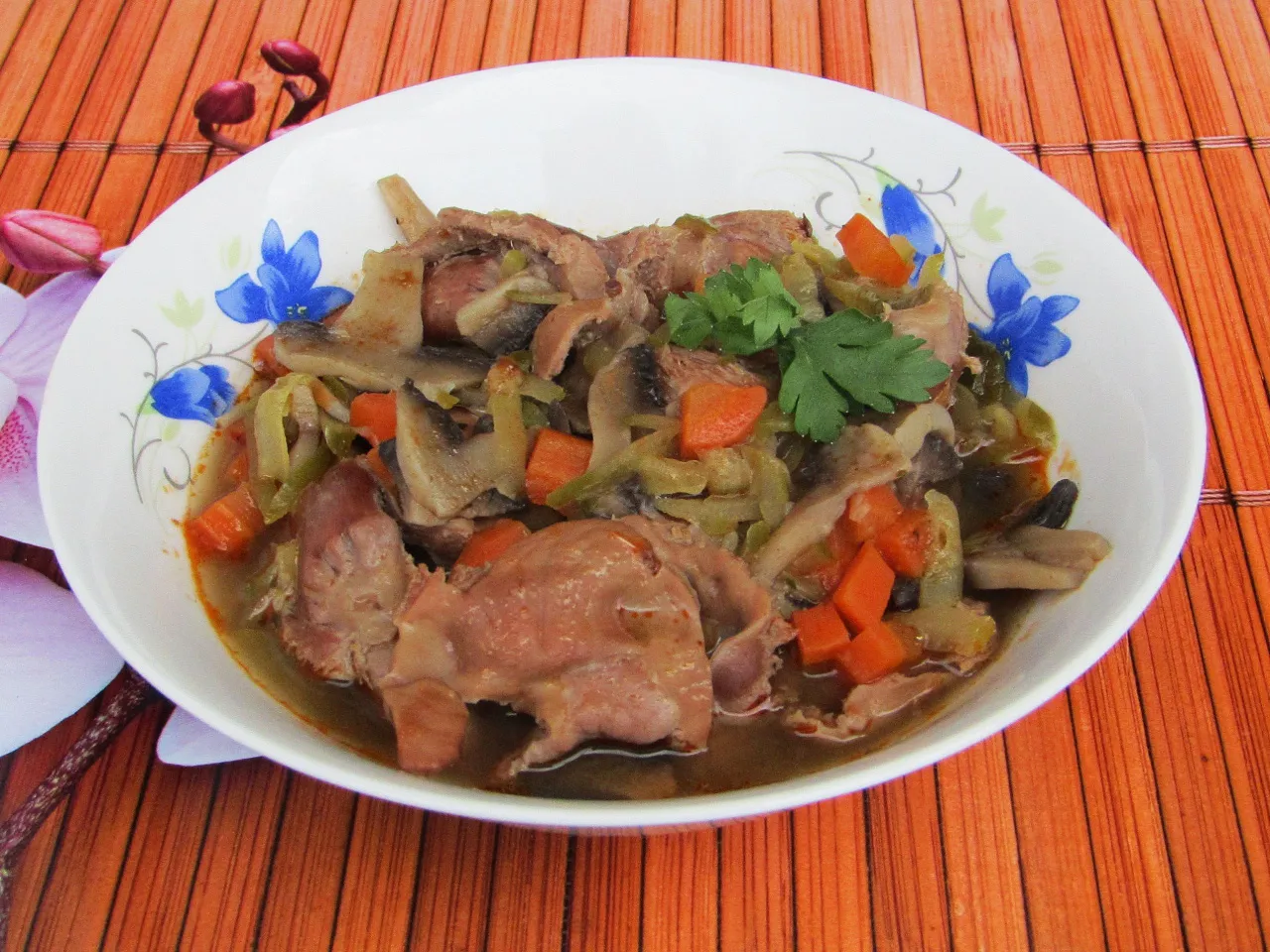 Gulasz z żołądk&oacute;w drobiowych na talerzu z kaszą i og&oacute;rkiem kiszonym