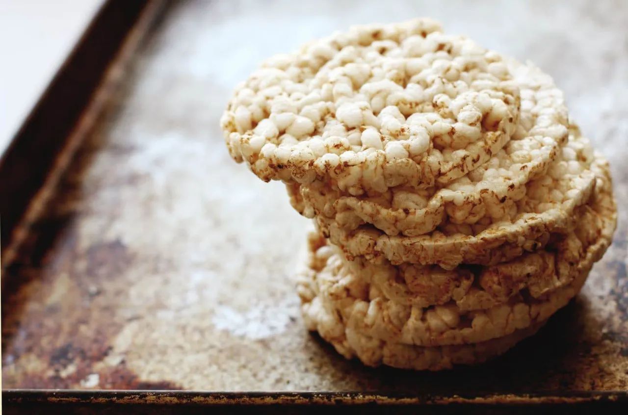 Stos wafli ryżowych na metalowej blasze. Czy wafle ryżowe są zdrowe? To pytanie zadaje sobie wiele osób, sięgając po tę lekką przekąskę.