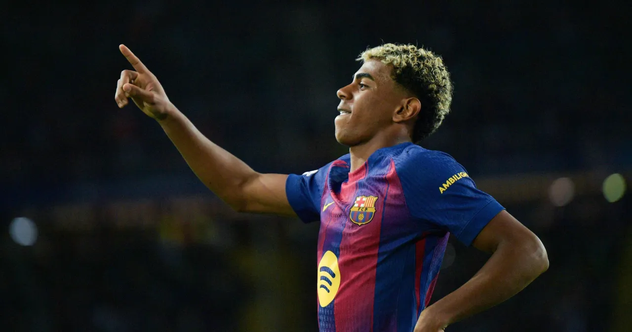 Młody piłkarz Barcelony z charakterystyczną fryzurą, radośnie wskazuje palcem w górę, jakby świętował moment, kiedy Barcelona wygrała Ligę Mistrzów.