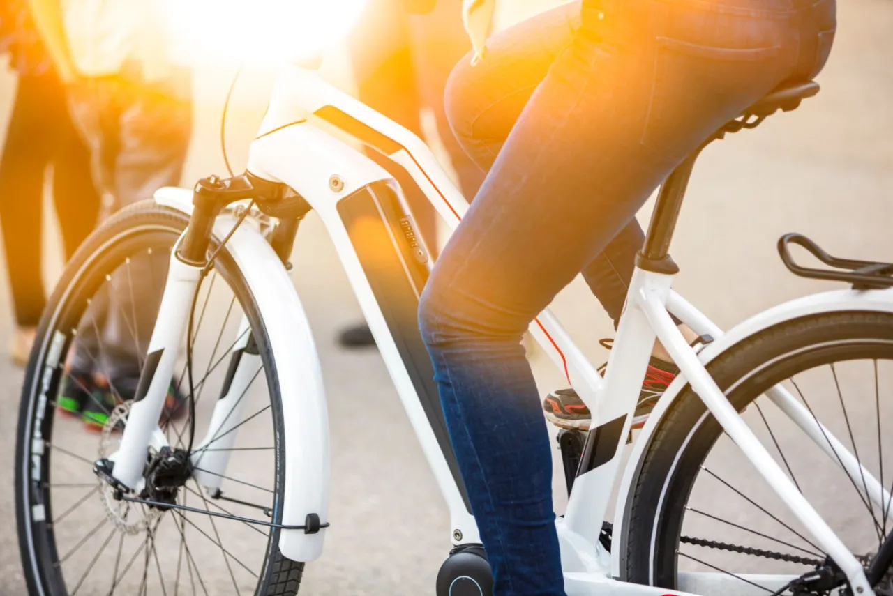 Osoba na rowerze elektrycznym, korzystająca z dofinansowania do roweru elektrycznego dla każdego, kto chce jeździć ekologicznie.