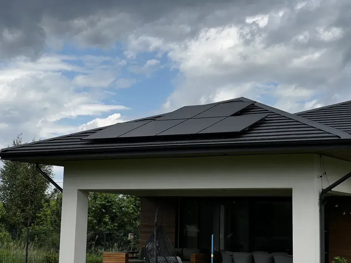 Nowoczesny dom z panelami fotowoltaicznymi na dachu. Czy ocieplenie dachu można odliczyć od podatku? Warto sprawdzić!