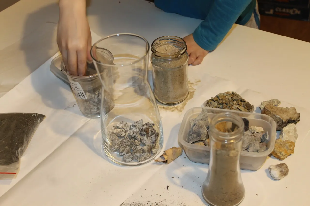 dziecko obserwujące warstwy ziemi w słoiku