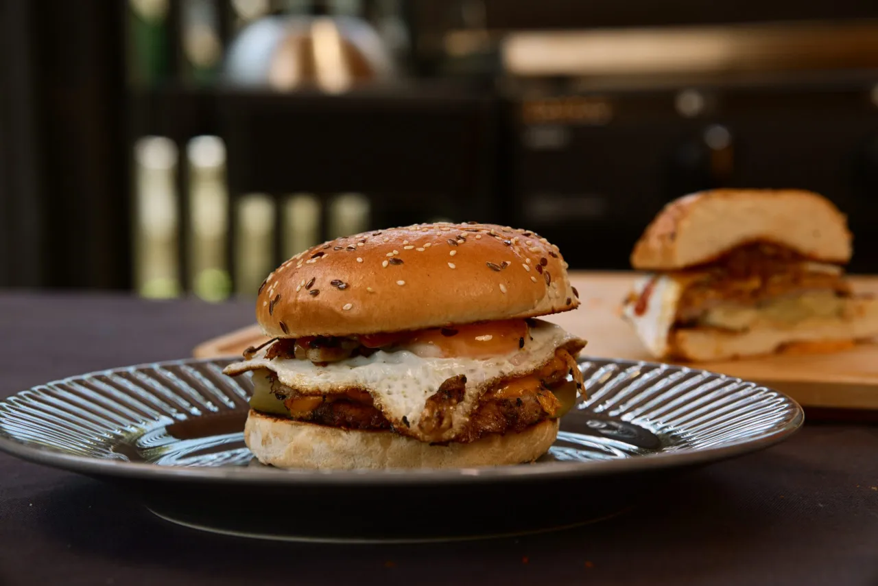 przygotowanie burgera smash, rozgniatanie mięsa na patelni