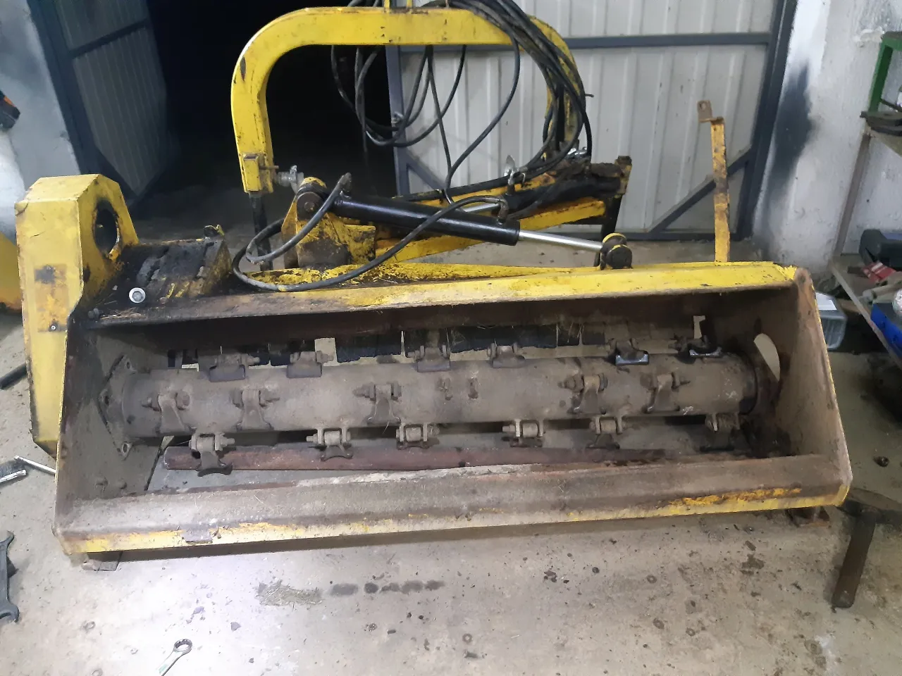 Ż&oacute;łty wał do kosiarki bijakowej z widocznymi nożami i mocowaniami. Może to być pomocne przy pytaniu jak zrobić wał do kosiarki bijakowej.