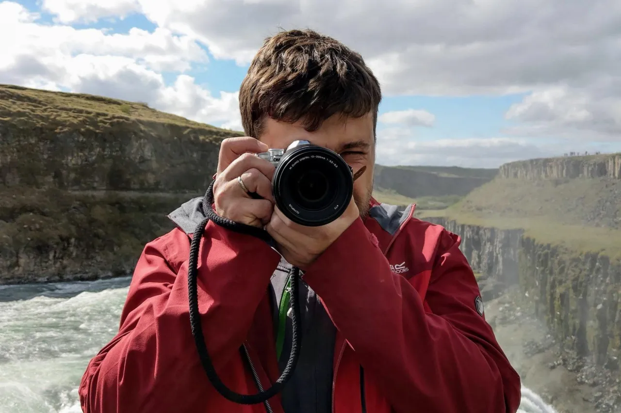 fotograf w podr&oacute;ży z aparatem i obiektywem