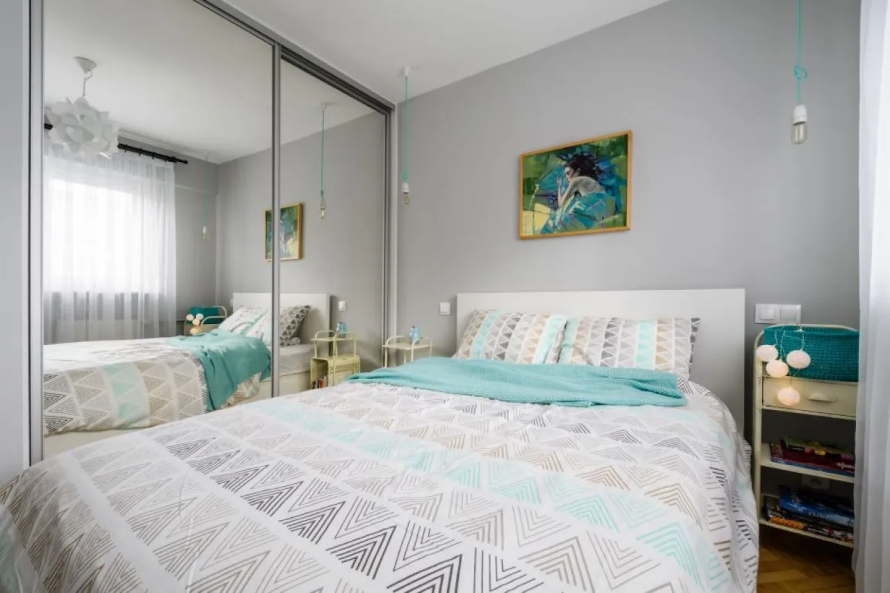 mała sypialnia jasne kolory lustra oświetlenie