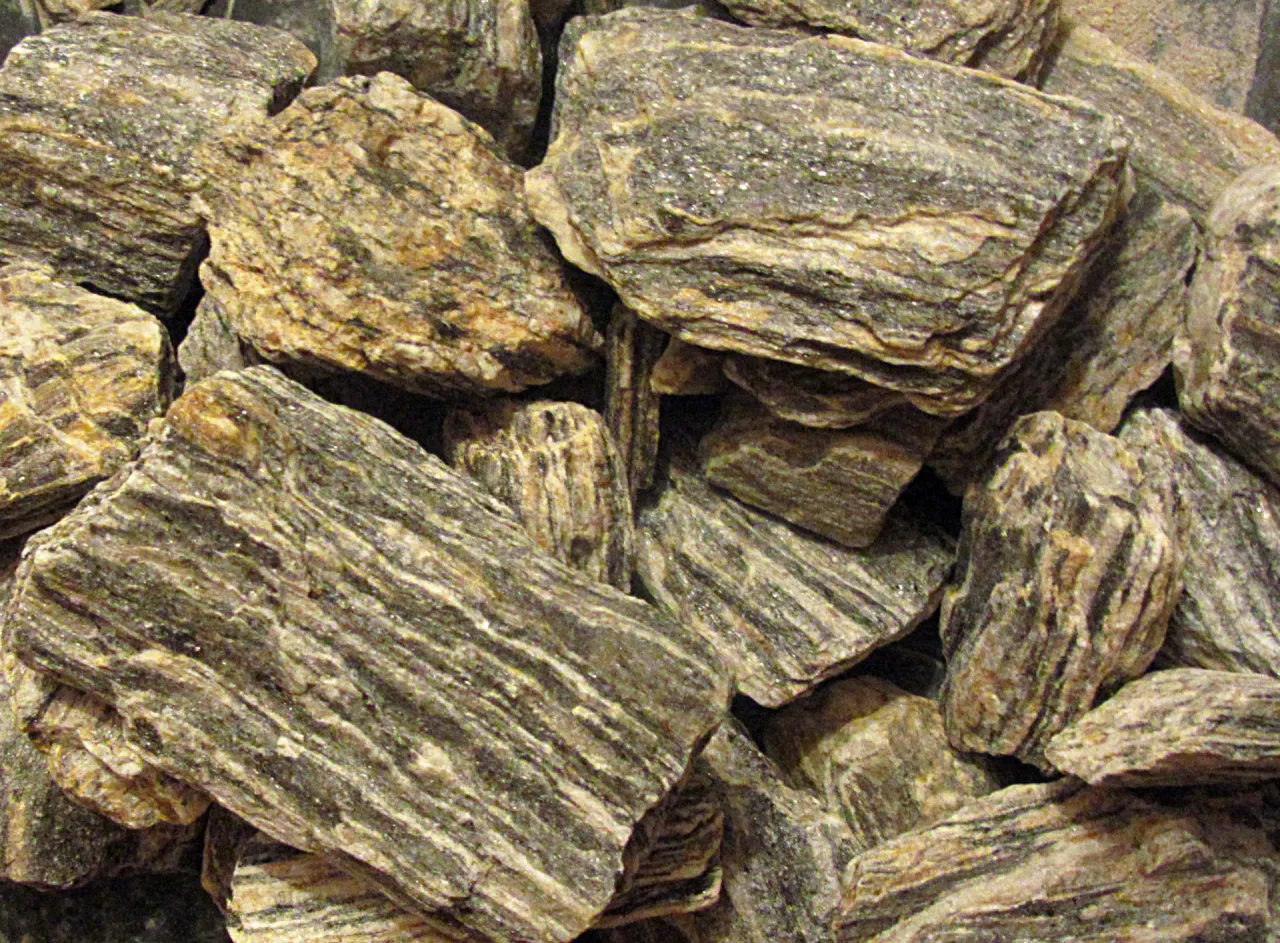 Warstwowe skały, przypominające te, z których powstały Sudety, z widocznymi pasmami minerałów.