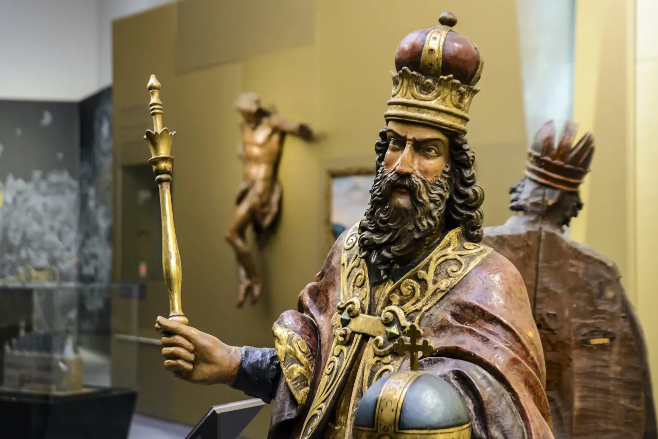 Rzeźby przedstawiające królów Francji chronologicznie, z koroną i berłem. W tle widać krucyfiks.