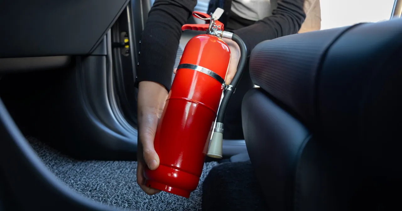 Ręka trzymająca gaśnicę samochodową i banknoty