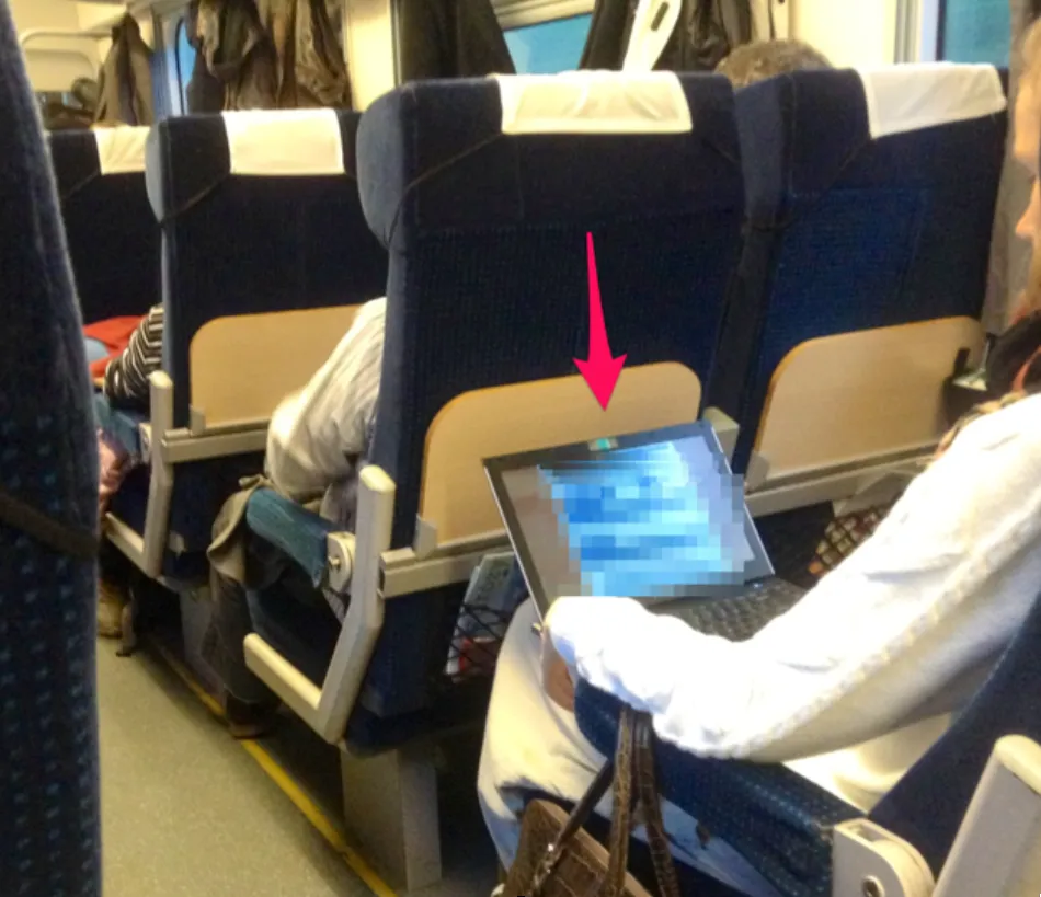 Pasażer Pendolino korzysta z laptopa, osoba z telefonem w pociągu