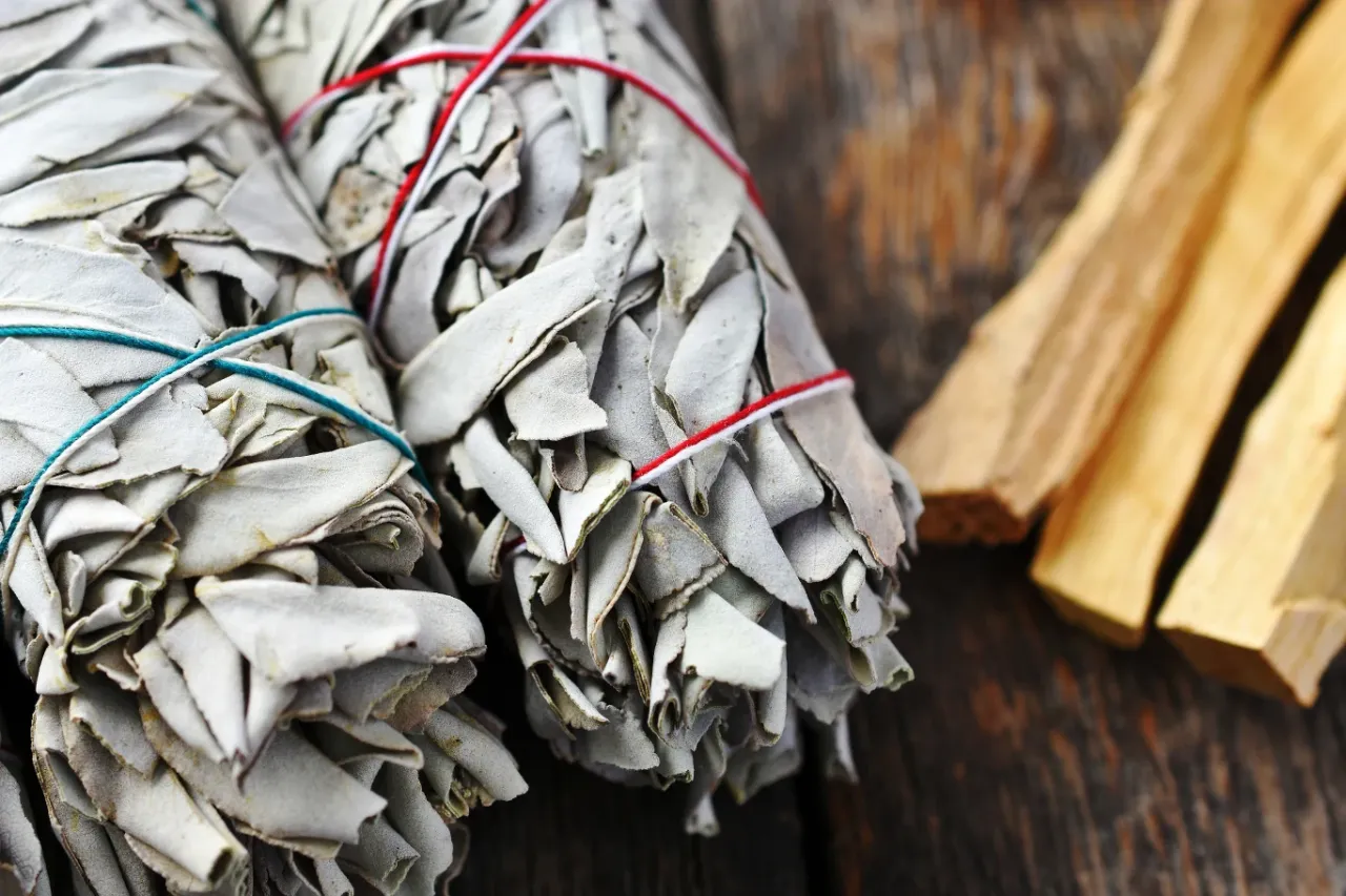 Kobieta okadzająca dom białą szałwią