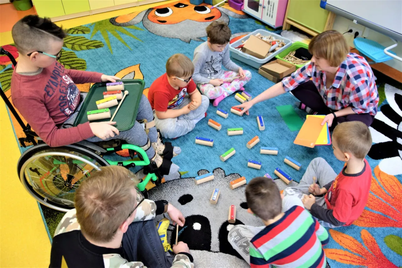 dziecko gra na cymbałkach z rodziną