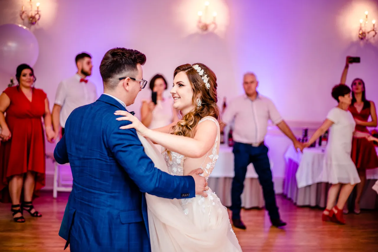 Para młoda tańczy pierwszy taniec, a goście weselni bawią się w tle. Jak zem lecioł na wesele, to właśnie taki widok zastałem.