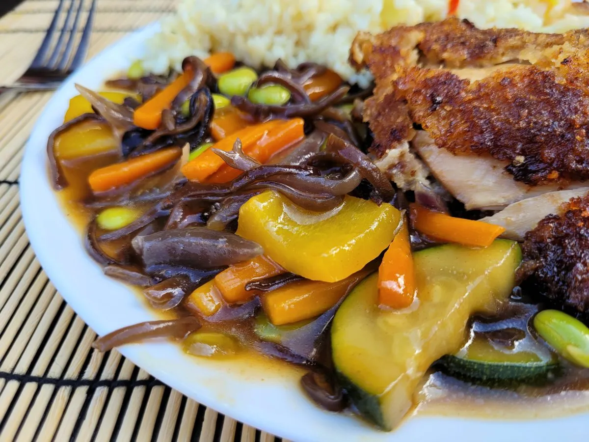 Kolorowe warzywa w sosie sojowym: marchewka, papryka, cukinia, grzyby mun i edamame, podane z ryżem i kurczakiem.