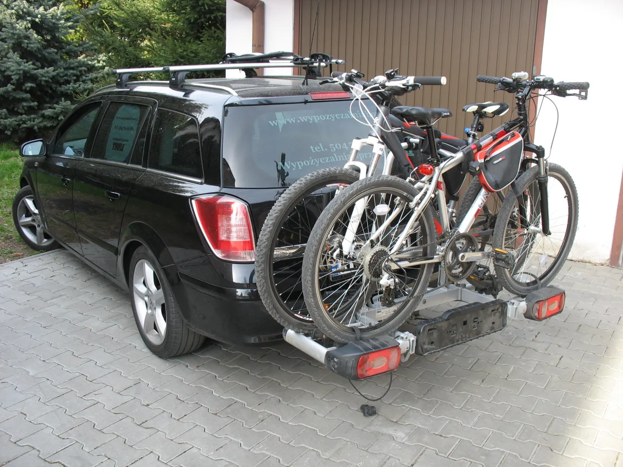 Czarny kombi z dwoma rowerami na bagażniku. Ile rower&oacute;w na dachu? Żadne, te są z tyłu!