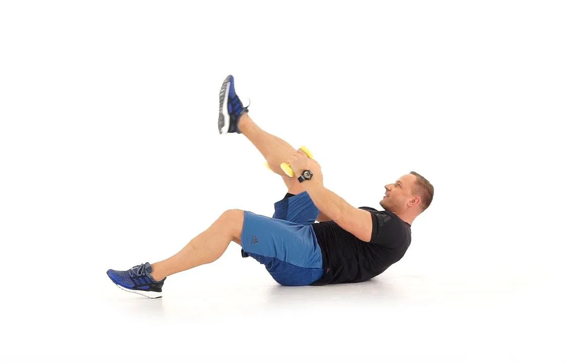 osoba wykonująca spięcia brzucha z hantlem, symbolizującym obciążenie i progresję