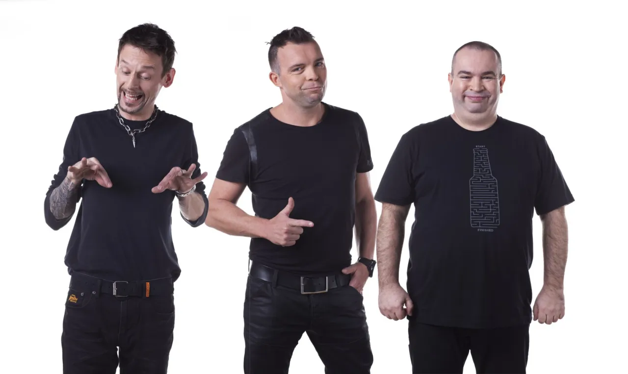 Trzej członkowie Kabaretu Ani Mru Mru w czarnych strojach pozują do zdjęcia.