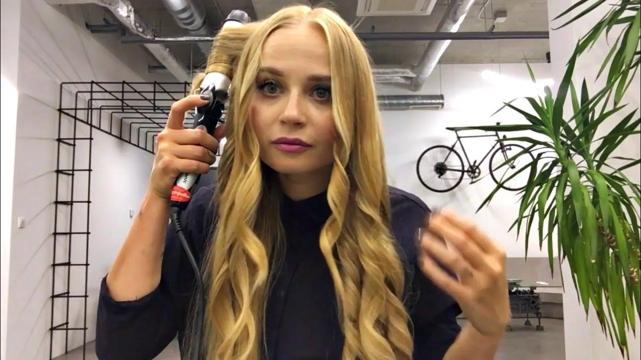 kobieta kręcąca włosy lok&oacute;wką po botoksie