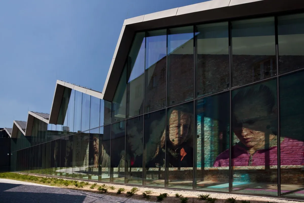 Nowoczesna architektura muzeum sztuki wsp&oacute;łczesnej Krak&oacute;w z wielkoformatowymi portretami na szkle.