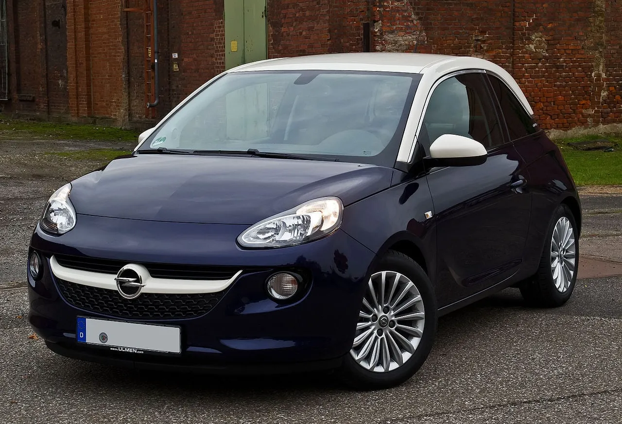 Granatowy Opel Adam z białym dachem, idealne pierwsze auto dla dziewczyny. Stylowy i kompaktowy, gotowy na miejskie przygody.