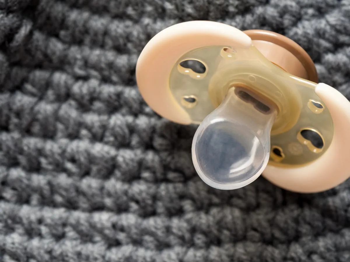 Rodzic sprawdzający smoczek dziecka pod kątem uszkodzeń