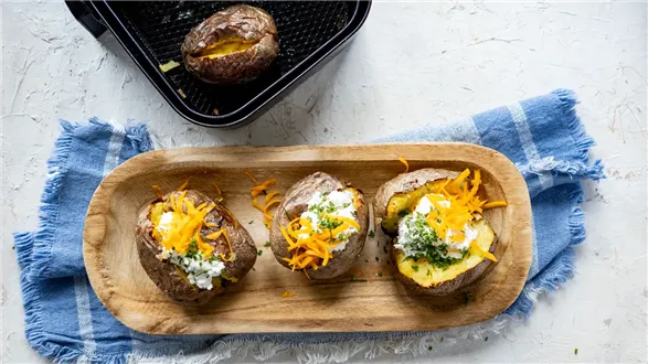 Pieczone ziemniaki z airfryera z serkiem czosnkowym, serem mimolette i szczypiorkiem